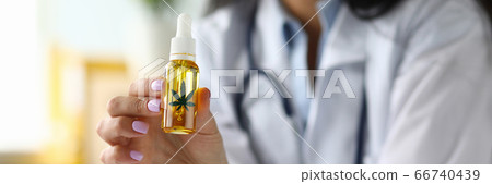 Arms of female GP holding dropper jar of cannabis concentrate oil Arms of female GP holding dropper jar of cannabis concentrate oil 66740439