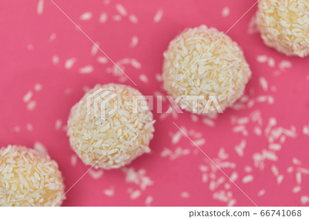 Candies covered by shredded coconut. 66741068