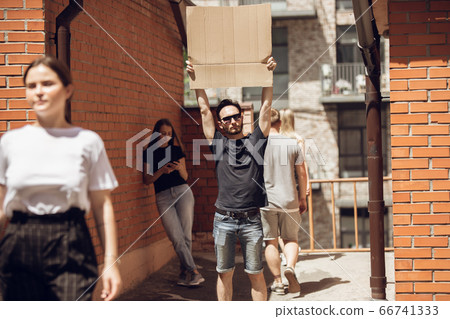 Dude with sign - man stands protesting things that annoy him 66741333