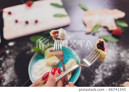 Dumplings, filled with strawberries. Varenyky, vareniki, pierogi, pyrohy - dumplings with filling. View from above, top studio shot. 66741345