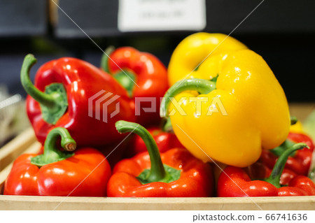 Wet bell pepper lying under light in grocery. Close-up of red and yellow organic vegetables in supermarket. Healthy food, nutrition, vegeterianism, assortment. 66741636