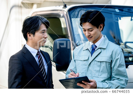 Worker and businessman meeting in front of truck Worker and businessman meeting in front of truck 66744035