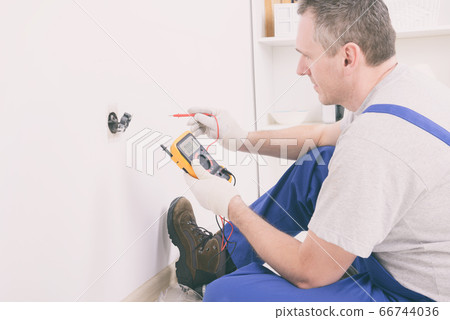 Electrician checking socket Electrician checking socket 66744036