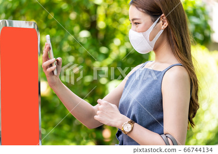 Asian woman scaning online queue for restaurant. 66744134