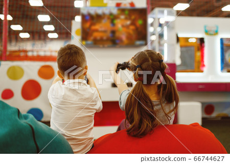 Children plays game console, entertainment center Children plays game console, entertainment center 66744627