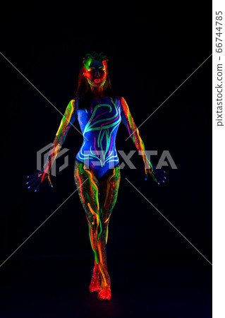 Female model with colorful ultraviolet body in dark 66744785