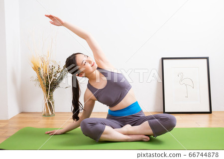 女人在家裡的客廳裡做瑜伽 女人在家裡的客廳裡做瑜伽 66744878