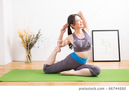 女人在家裡的客廳裡做瑜伽 女人在家裡的客廳裡做瑜伽 66744880