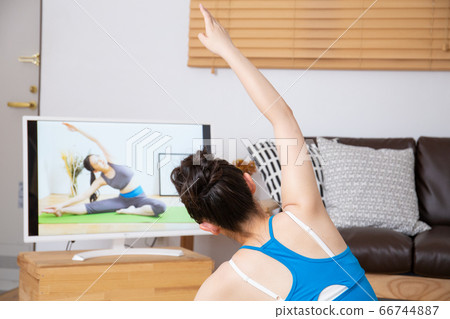 女人在房間裡做在線瑜伽 女人在房間裡做在線瑜伽 66744887