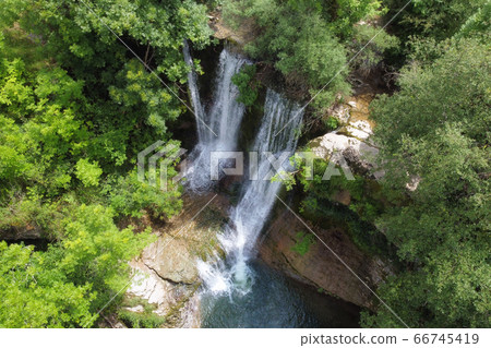 Aerial view of an Idyllic rain forest waterfall, stream flowing in the lush green forest. 66745419