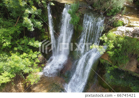 Idyllic rain forest waterfall, stream flowing in the lush green forest. 66745421