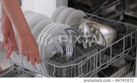 Woman using dish washing machine at kitchen. 66745872