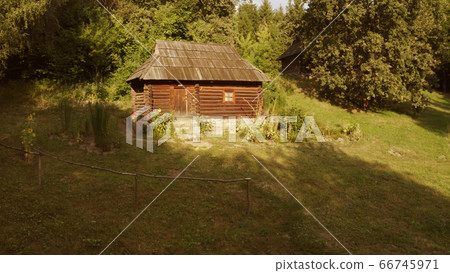 Small log building on sunny day in the forest. 66745971