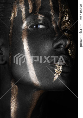 fashion portrait of a dark-skinned girl with gold make-up. Beauty face. fashion portrait of a dark-skinned girl with gold make-up. Beauty face. 66746856
