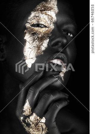 fashion portrait of a dark-skinned girl with gold make-up. Beauty face. fashion portrait of a dark-skinned girl with gold make-up. Beauty face. 66746858