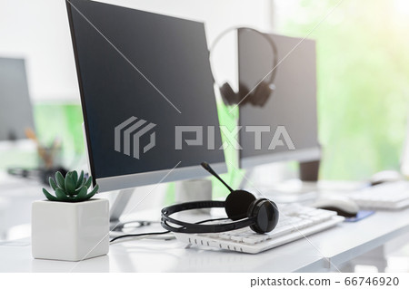 Call center and customer service. Computer monitor with blank space for your design and VOIP headset on desk in office 66746920