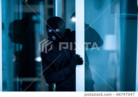 Thief breaking into apartment or office to steal something 66747047