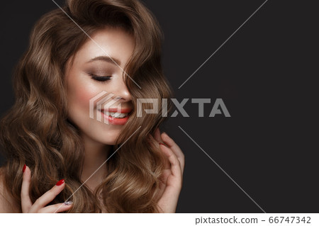 Beautiful brown-haired girl with a perfectly curls hair, and classic make-up. Beauty face and hair. 66747342