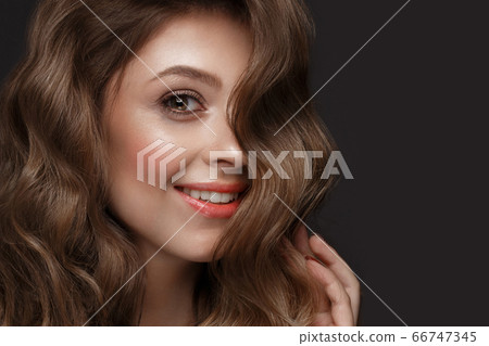 Beautiful brown-haired girl with a perfectly curls hair, and classic make-up. Beauty face and hair. 66747345