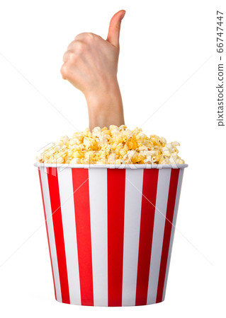 Female hand sticks out of a bucket with popcorn 66747447