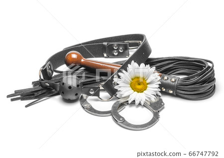 bdsm black leather gag with handcuffs and a yellow daisy flower on a white background bdsm black leather gag with handcuffs and a yellow daisy flower on a white background 66747792