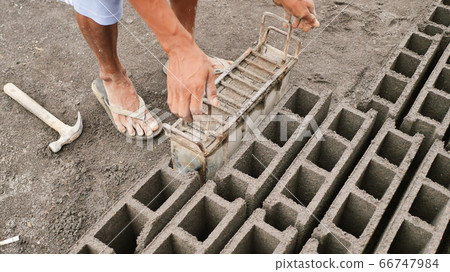 Man manually produces brick molds for construction from volcanic ash in the city of Legazpi. Philippines. Man manually produces brick molds for construction from volcanic ash in the city of Legazpi. Philippines. 66747984