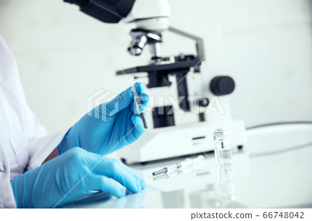 Hands holds a syringe. Hands in medical gloves 66748042