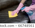 Woman wipe sofa with germicidal spray and wipe with towel. 66748561