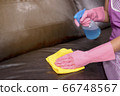 Woman wipe sofa with germicidal spray and wipe with towel. 66748567