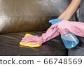 Woman wipe sofa with germicidal spray and wipe with towel. 66748569