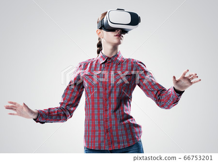 Girl in mask experiencing virtual reality as new entertainment device Girl in mask experiencing virtual reality as new entertainment device 66753201
