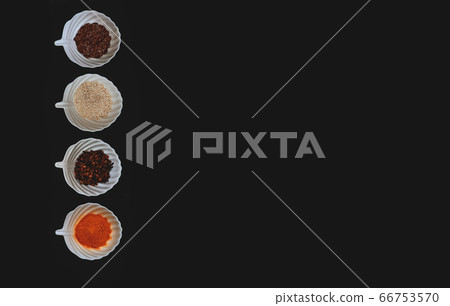 Spices and grains in white cups on a black background. 66753570