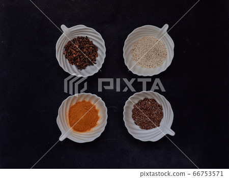 Spices and grains in white cups on a black background. 66753571