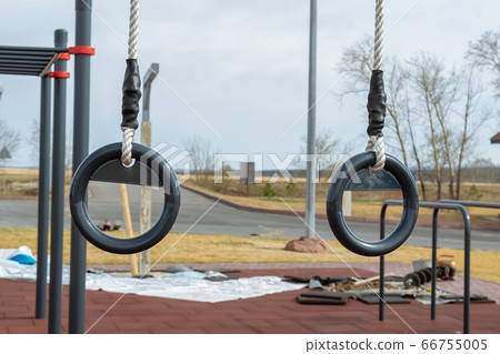 gymnastic rings hang on the outdoor sports field 66755005