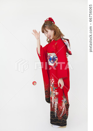 A woman in furisode playing with yo-yo 66756065