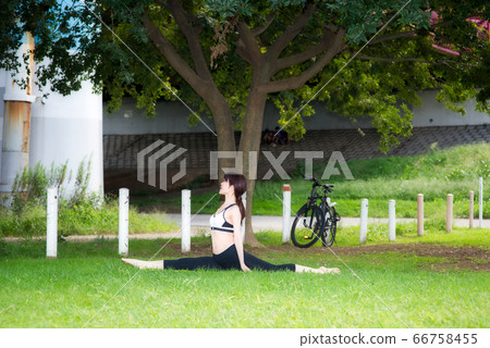 Middle age woman stretching on grass Middle age woman stretching on grass 66758455