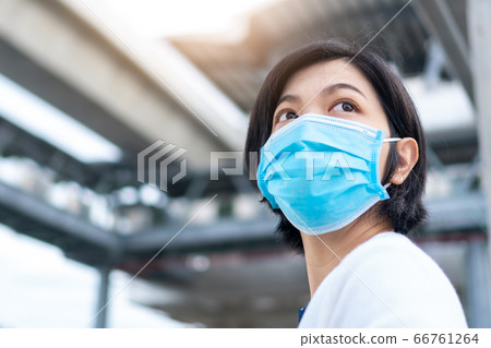 Young Beautiful Asian woman wearing blue surgical mask Young Beautiful Asian woman wearing blue surgical mask 66761264