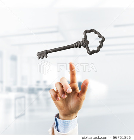 Retro metal key and male palm against office interior. Mixed media 66761896