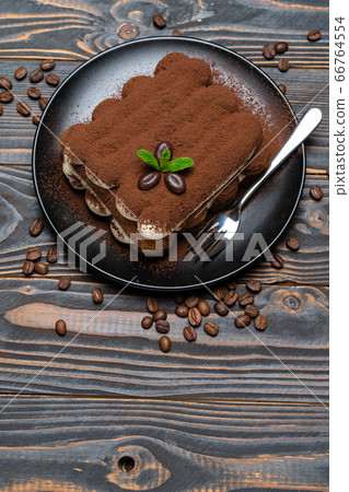 Classic tiramisu dessert on ceramic plate on wooden background Classic tiramisu dessert on ceramic plate on wooden background 66764554