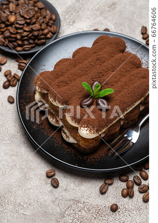 Classic tiramisu dessert on ceramic plate on concrete background Classic tiramisu dessert on ceramic plate on concrete background 66764606