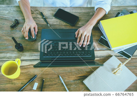 women sitting working at on the wood table working with a notebook And drink coffee at home women sitting working at on the wood table working with a notebook And drink coffee at home 66764765