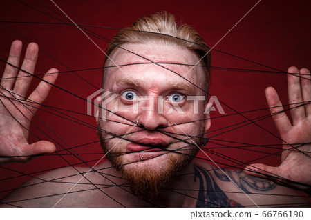 Photo of tangled in black threads scared man Photo of tangled in black threads scared man 66766190