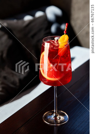 Glass of aperol spritz cocktail on wooden table in 66767135