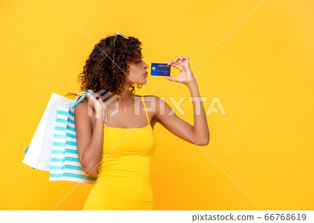 Fashionable curly hair woman with credit card and shopping bags 66768619