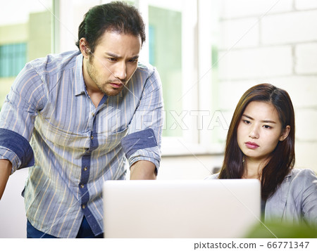 frustrated asian business people looking at laptop computer in office frustrated asian business people looking at laptop computer in office 66771347