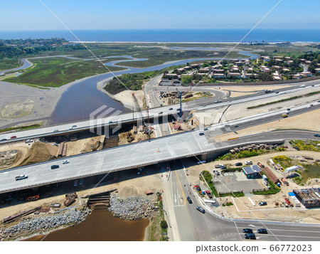 Aerial view of highway bridge construction over small river 66772023