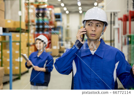 Worker man making a phone call in distribution warehouse Worker man making a phone call in distribution warehouse 66772114
