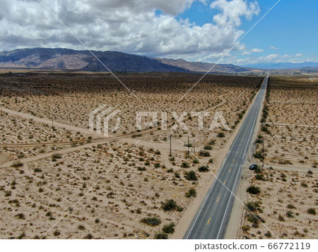 Aerial view of endless desert straight dusty asphalt road in Joshua Tree Park. USA. Aerial view of endless desert straight dusty asphalt road in Joshua Tree Park. USA. 66772119