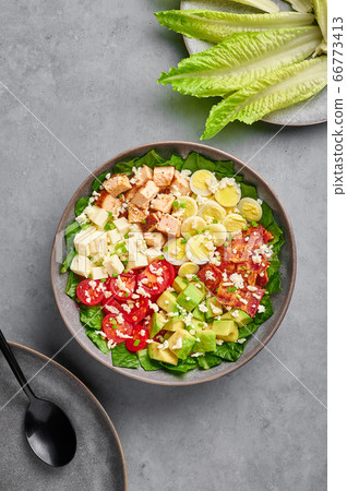 Cobb Salad in gray matte bowl on concrete backdrop. USA food and meal. American cuisine dish Cobb Salad in gray matte bowl on concrete backdrop. USA food and meal. American cuisine dish 66773413