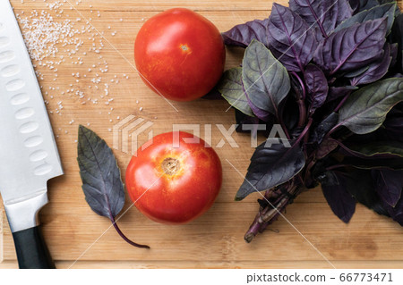 Top view on couple red tomatos and basil leafs Top view on couple red tomatos and basil leafs 66773471